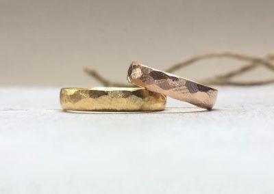 Hammerschlagringe in Gold und Rotgold im Felsmuster geschmiedet.
