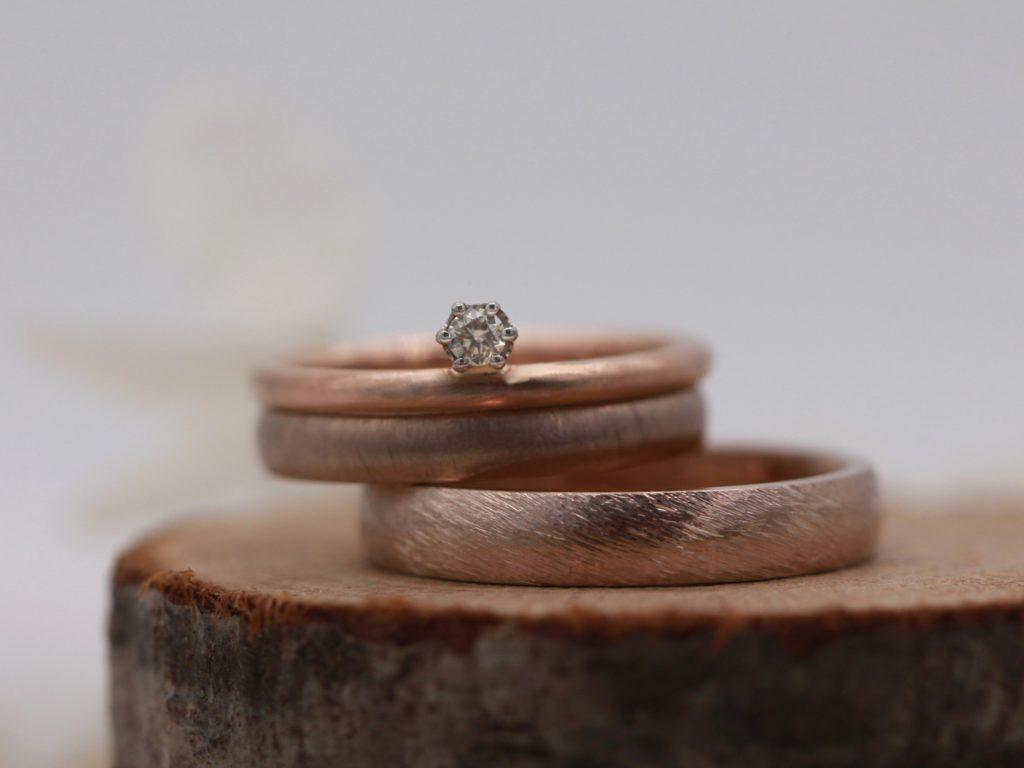 Diese matten Ringe aus Toffeegold (schwammatt und Düne) werden mit einem Vorsteckring aus Rotgold kombiniert.
