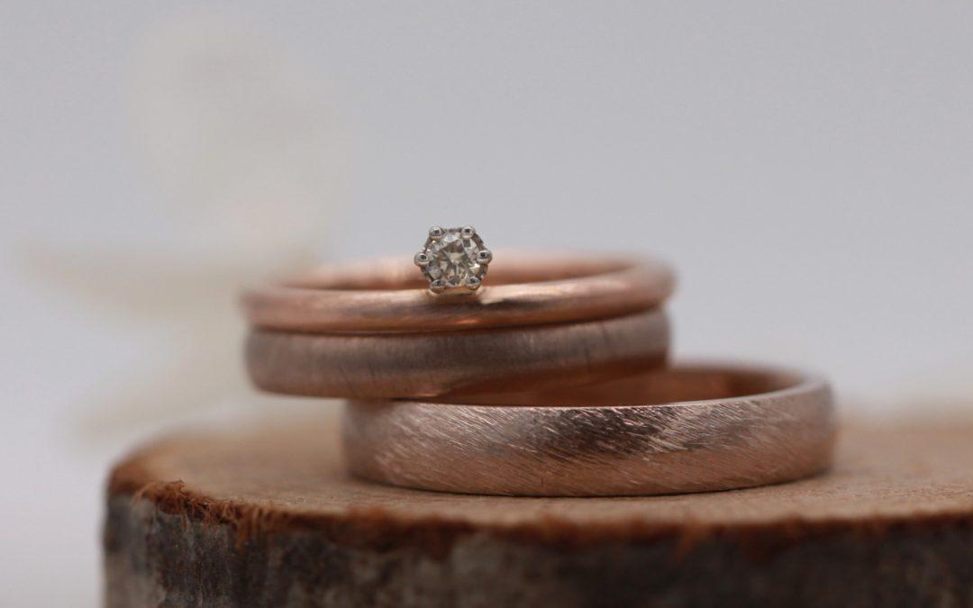 Diese matten Ringe aus Toffeegold (schwammatt und Düne) werden mit einem Vorsteckring aus Rotgold kombiniert.