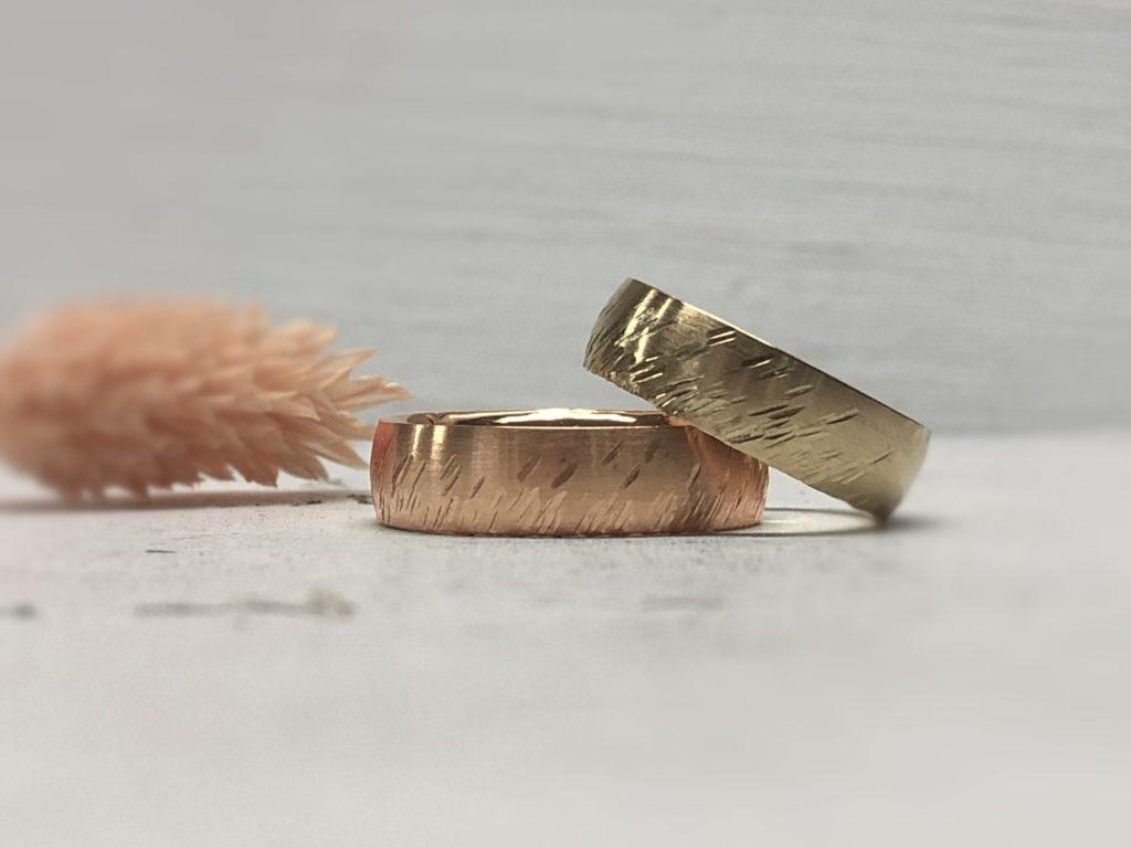 Dicker Rotgoldring und dicker Haselnussgoldring bzw. Sandgoldring mit schrägem Sternschnuppenmuster