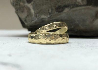 Eheringe mit Herzen auf beiden Ringen mit Herzschlagmuster und Bergweltmuster in Gold