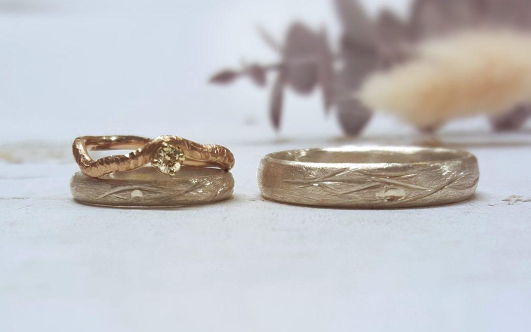 Eheringset mit floralem Muster und Verlobungsring haselnussgoldiges Sandgold mit Sanddornmuster