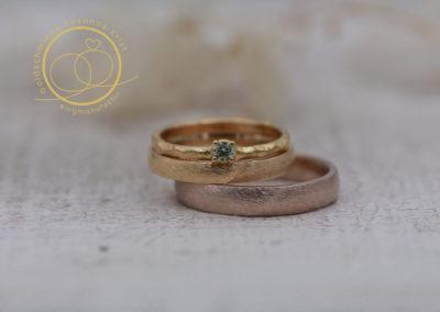 Eine besonders hübsche Trauringkombi: Haselnussgold (Toffee) mit Gelbgold, dazu Verlobungsring mit grünem Stein Minti