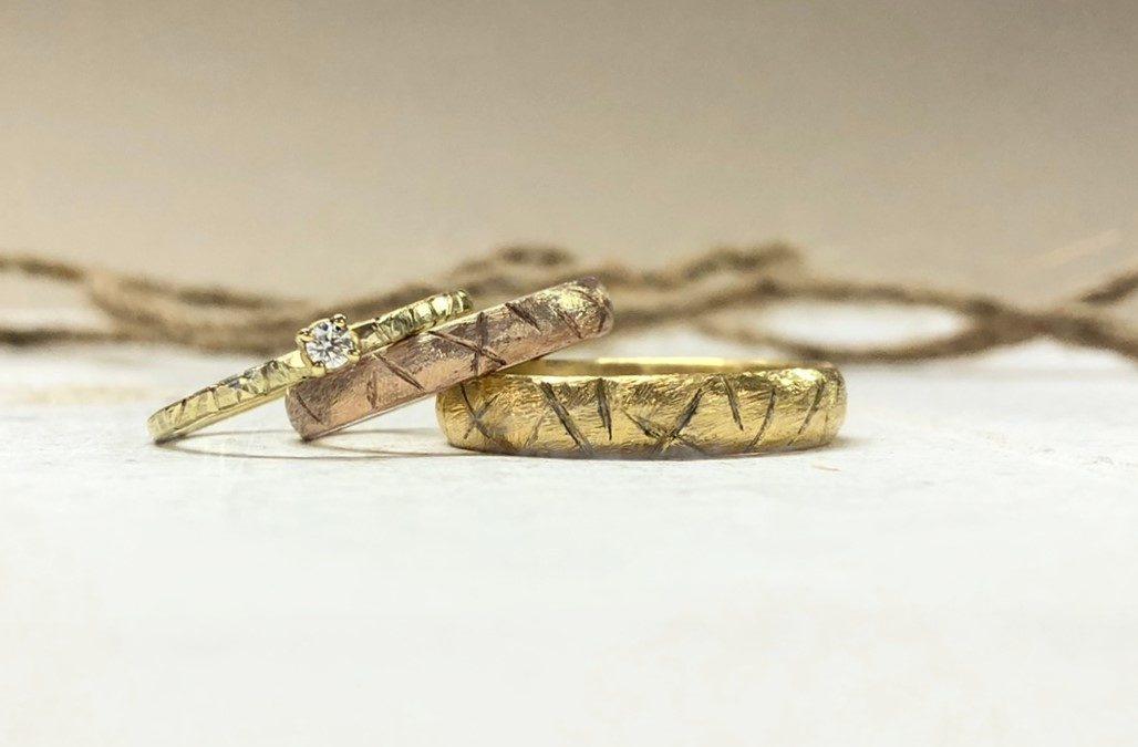 Raue Trauringe in Rotgold und Gold mit Vorsteckring Ligni handgeschmiedet mit Kerbholzmuster