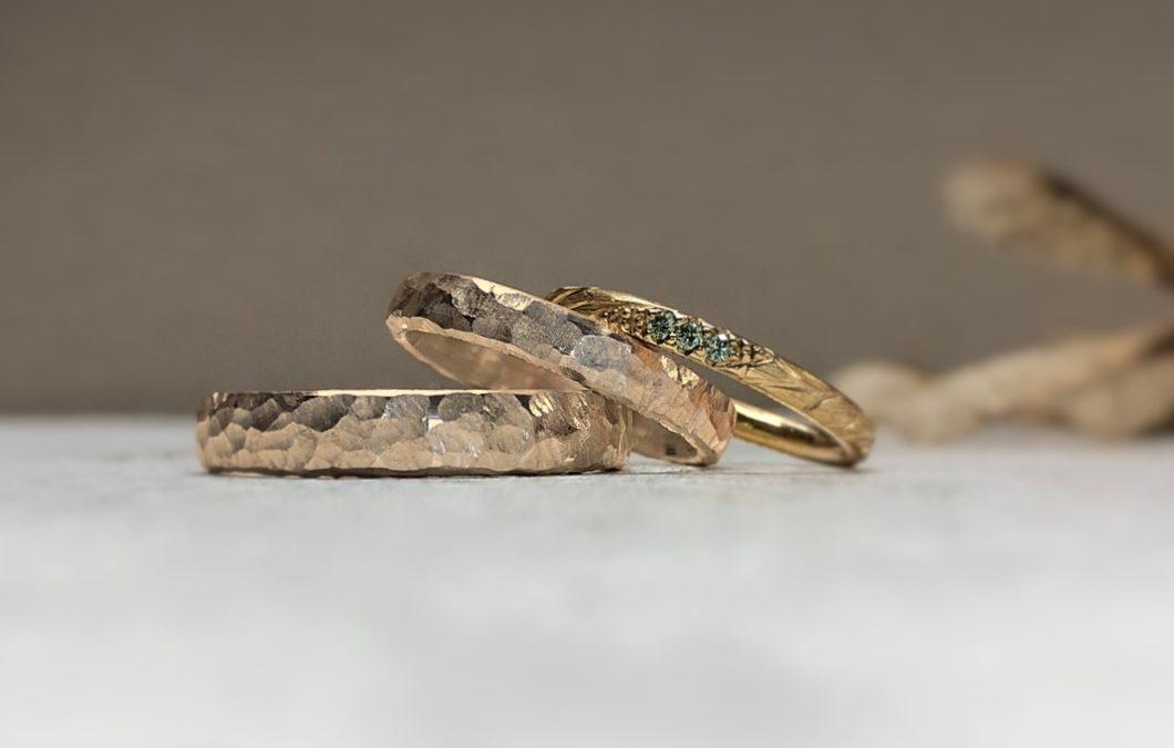 Grobe Hammerschlagringe Rotgold mit Grübchenmuster und Verlobungsring mit grünen Steinchen