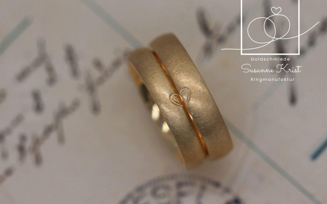 Matte Trauringe aus Gold mit Herzhälften.