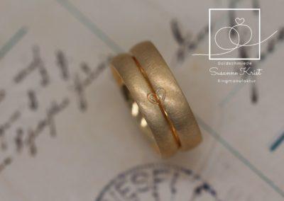 Matte Trauringe aus Gold mit Herzhälften.