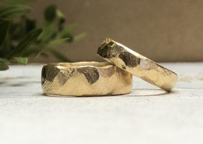 Raue facettierte Eheringe aus Gold mit Felsmuster Hammerschlag