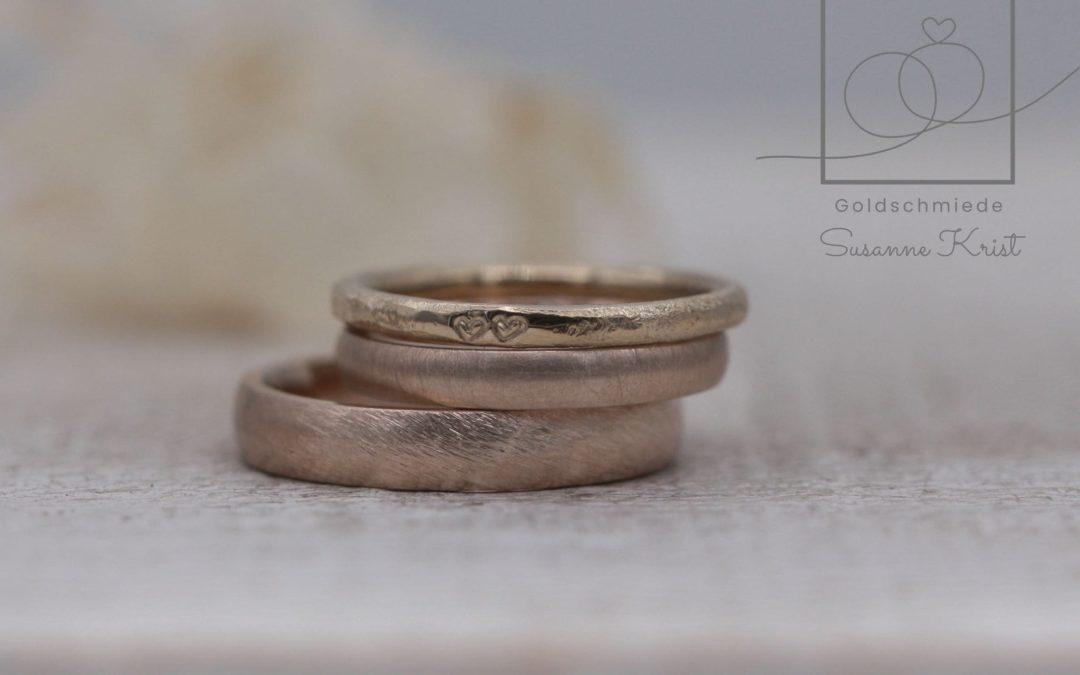 Rosebraune Eheringe aus Toffeegold bzw. Hazelnutgold mit Chamois Weissgold Herzchenring.