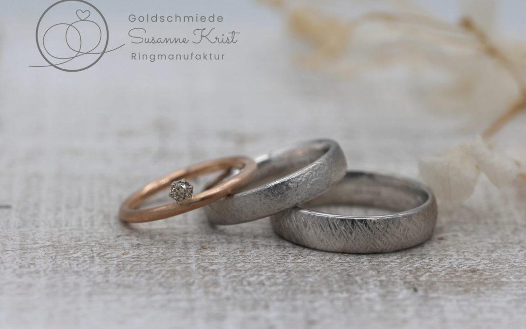 Rotgoldring als Vorsteckring und Platinringe mit Texturen.