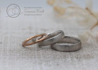 Rotgoldring als Vorsteckring und Platinringe mit Texturen.