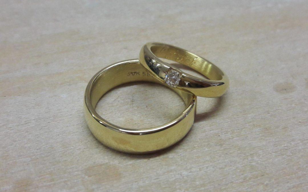 Rundlich gewölbte Trauringe in glänzendem Gelbgold mit Brillant.