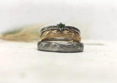 Verschiedenfarbige Eheringe mit angestecktem Verlobungsring bzw. Vorsteckring mit grünem Stein Vivina in Sanddornmuster